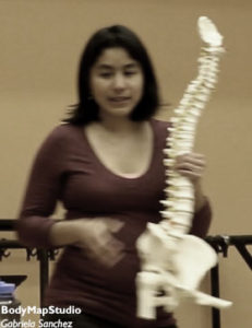 Gabriela holding a spine model